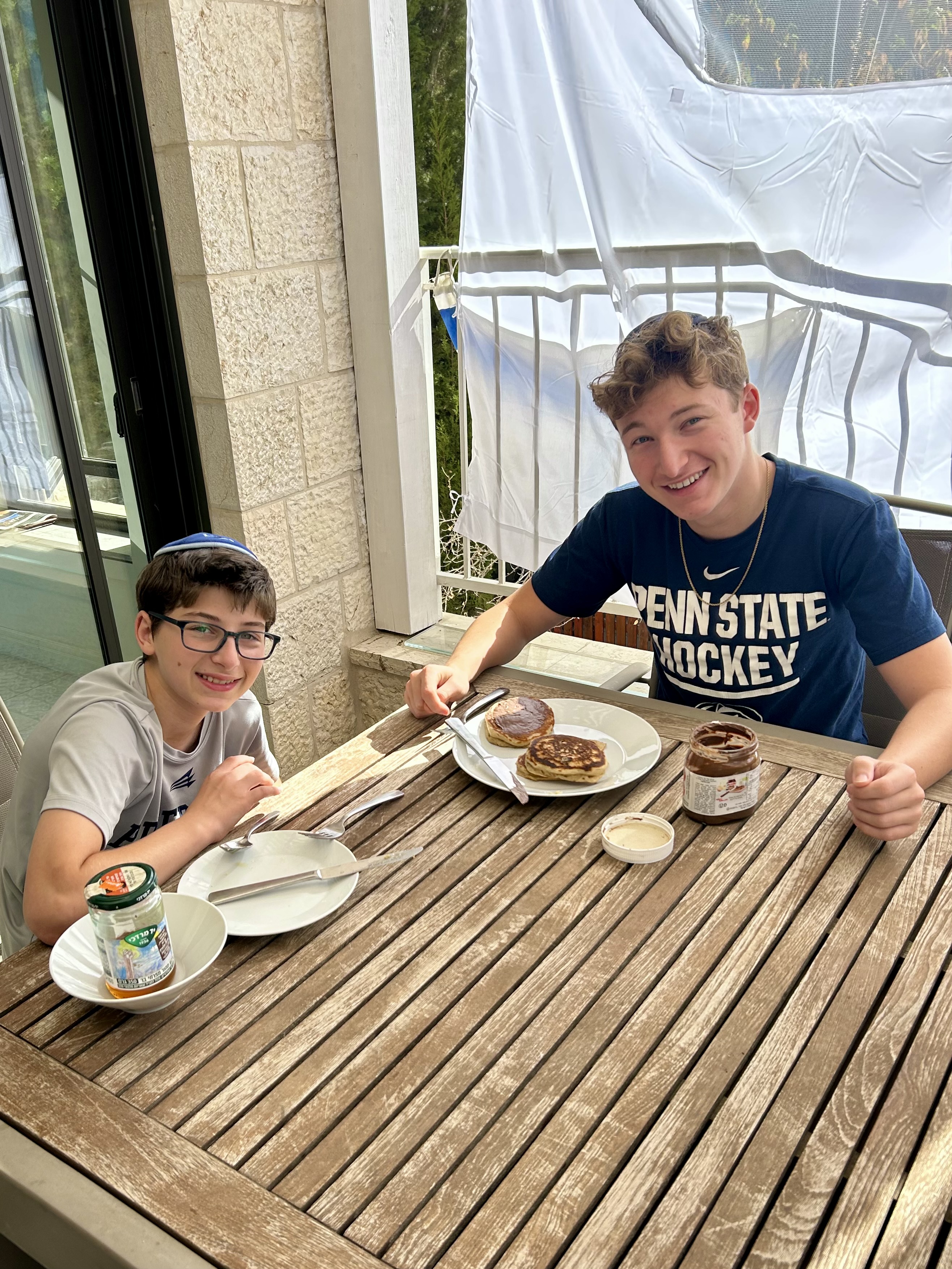 Eli and Avi enjoy some pancakes in the sukkah